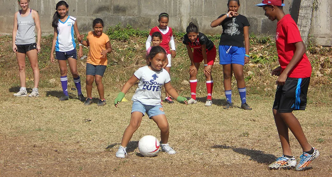 children playing soccer in a field