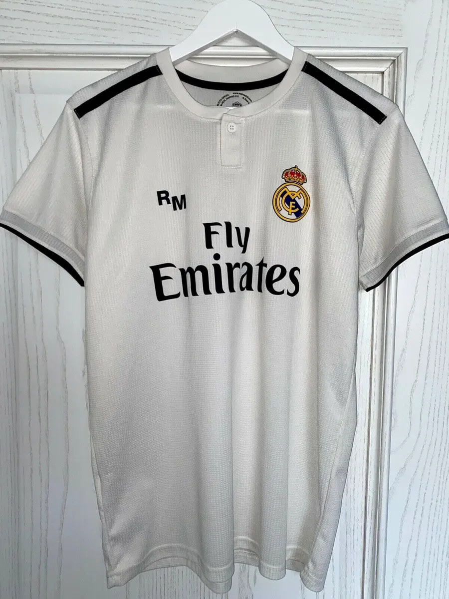 real madrid soccer jersey hanging on a door with sponsor logo