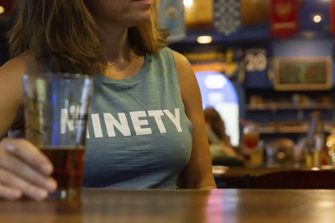 woman in ninety tank top holding glass indoors soccer lifestyle gear